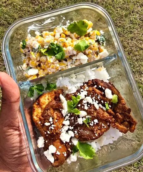 Smoky lime chicken over rice with a creamy sweet corn salad in a glass meal-prep box